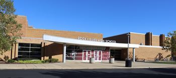 the front of a school building with an awning and a sidewalk